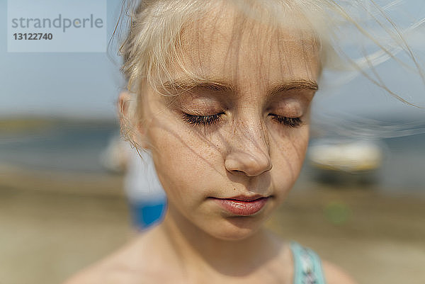 Nahaufnahme eines Mädchens mit geschlossenen Augen am Strand stehend