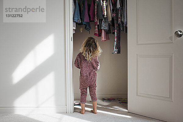 Rückansicht eines am Schrank stehenden Mädchens