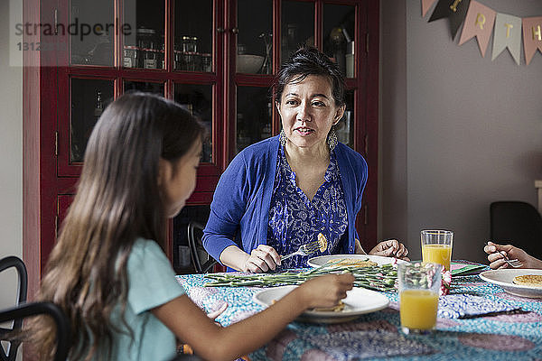 Mutter spricht mit Tochter beim Frühstück am Geburtstag