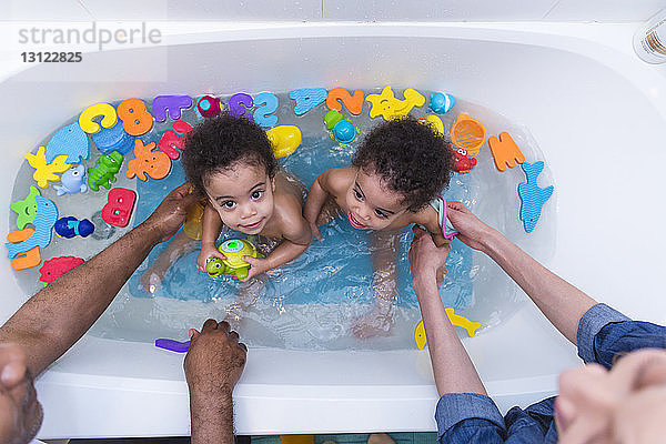 Hochwinkelansicht von Eltern  die ihre Töchter in der Badewanne baden