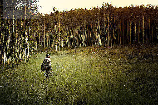 Jäger mit Pfeil und Bogen im Wald unterwegs