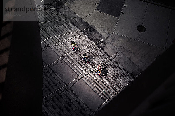 Hochwinkelaufnahme von Sportlerinnen  die in der Dämmerung auf Stufen laufen