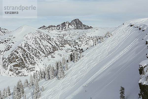 Landschaftliche Ansicht der Skipiste vor schneebedeckten Bergen