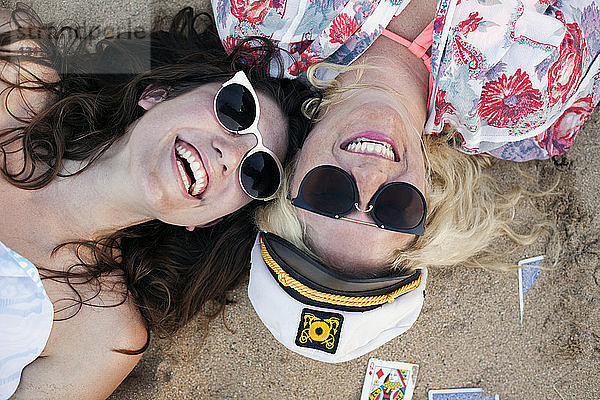 Draufsicht auf fröhliche Freunde  die am Strand liegen