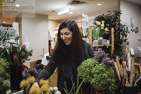 Floristin arrangiert Blumen im Laden