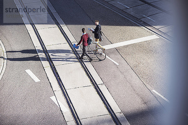Hochwinkelansicht von Freunden  die mit dem Fahrrad auf der Straße unterwegs sind