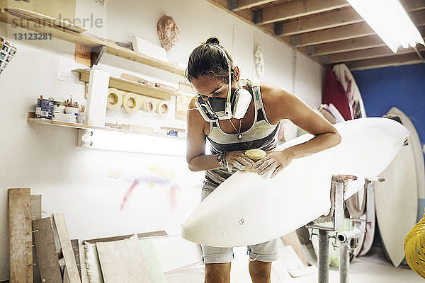 Frau formt Surfbrett beim Workshop