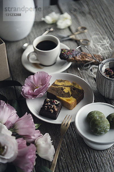 Hochwinkelansicht von Essen und Kaffee mit Rosen auf dem Tisch