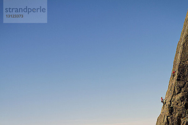 Fernsicht von Bergsteigern beim Bergsteigen vor klarem blauen Himmel