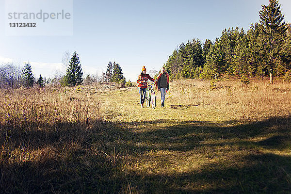 Freunde mit Radfahren auf dem Feld