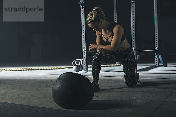 Weibliche Sportlerin trainiert mit dem Fitnessball im Fitnessstudio