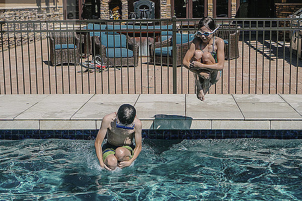 Schwester taucht  während der Bruder im Schwimmbad schwimmt