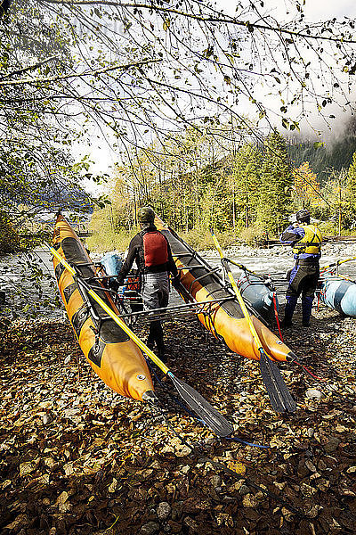 Rückansicht von Männern  die sich auf River-Rafting vorbereiten