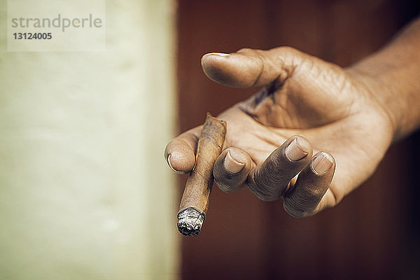Ausgeschnittenes Bild einer Zigarre in der Hand