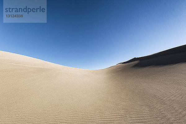 Landschaftliche Ansicht der Sanddünen vor klarem blauen Himmel