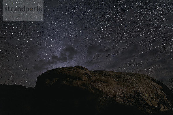 Tiefwinkelansicht von Felsformationen gegen das Sternenfeld bei Nacht