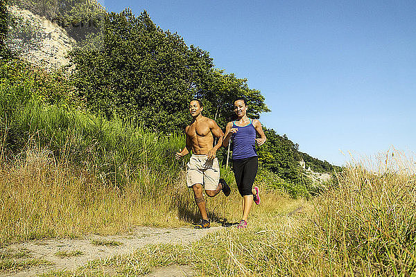 Paar joggt auf dem Feld gegen klaren Himmel