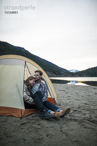 Junges Paar sitzt im Zelt am Seeufer im Silver Lake Provincial Park