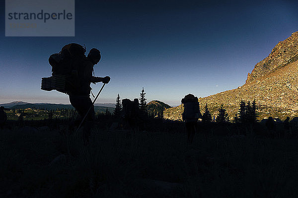 Silhouette einer Person  die auf einem Berg vor klarem Himmel geht