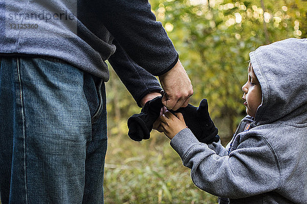 Mittelteil des Vaters  der beim Sohn Handschuhe trägt