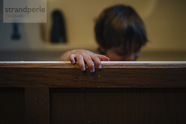 Junge in Holzbadewanne zu Hause