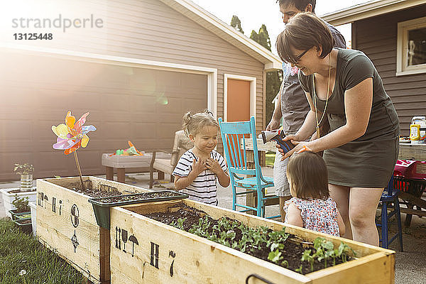 Eltern spielen mit Töchtern im Garten