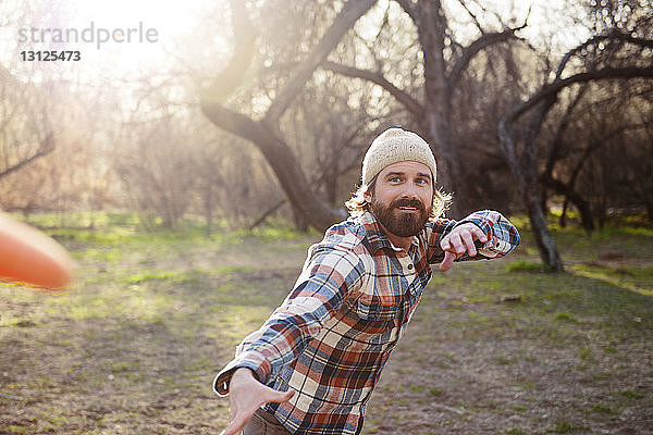 Porträt eines glücklichen Mannes beim Spielen im Wald