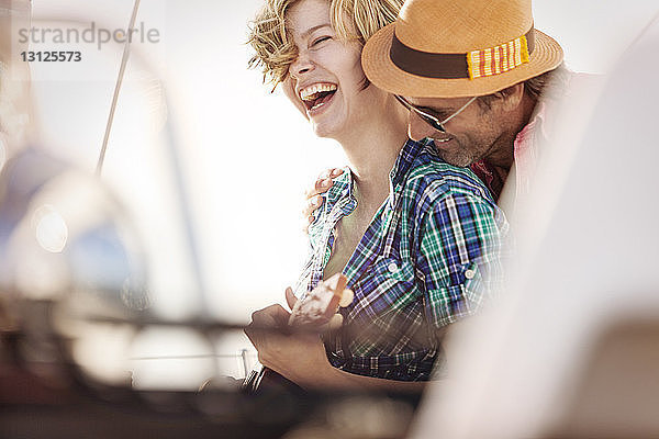 Lächelndes Paar genießt am sonnigen Tag am Boot