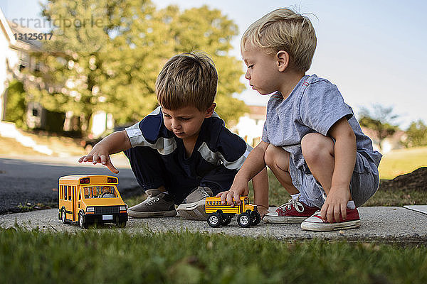 Brüder spielen mit Spielzeug im Garten