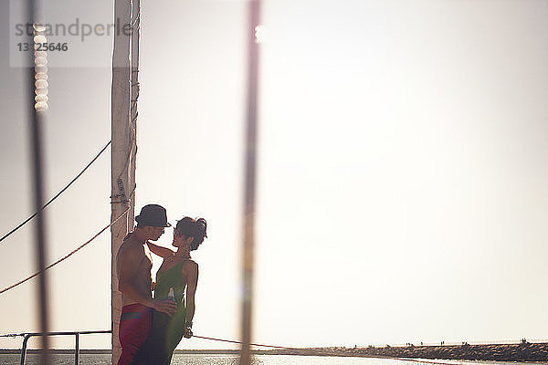 Paar  das am sonnigen Tag vor klarem Himmel auf dem Boot steht