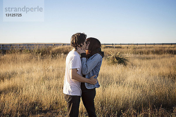 Seitenansicht eines zärtlichen Paares  das sich auf dem Spielfeld küsst