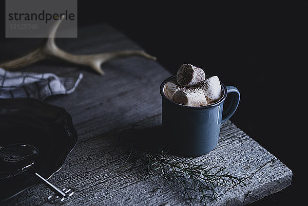 Tasse heiße Schokolade mit Marshmallow auf Holztisch