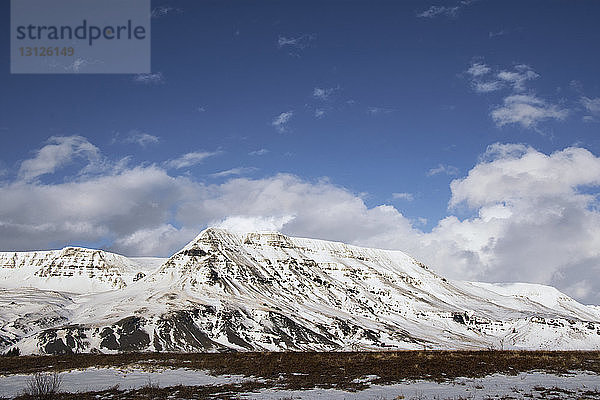 Idyllischer Blick auf schneebedeckten Berg vor blauem Himmel