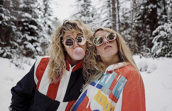 Verspielte Freundinnen mit Sonnenbrille im Winter
