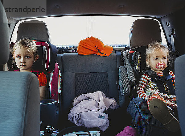 Schwestern schauen weg  während sie im Auto sitzen