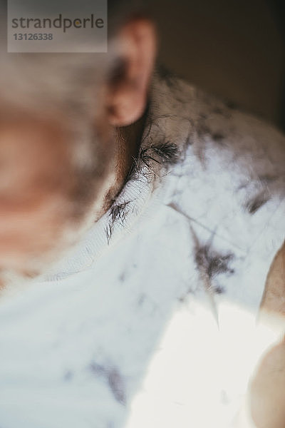 Ausgeschnittenes Bild eines Mannes mit Haaren auf der Schulter beim Friseur