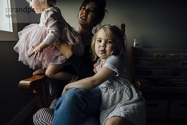 Porträt eines niedlichen Mädchens  das mit Mutter und Schwester sitzt