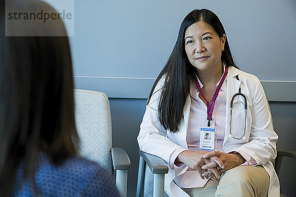 Ärztin sieht Frau im Wartezimmer eines Krankenhauses an