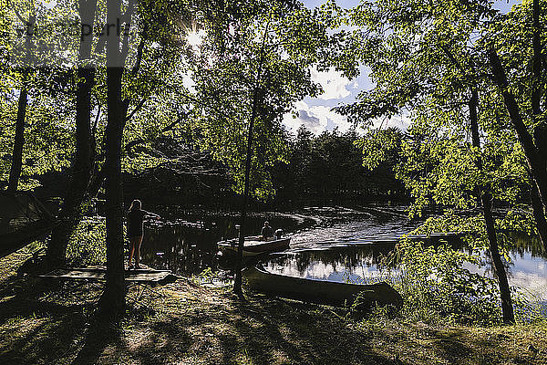 Mädchen sieht Vater beim Bootfahren auf einem See im Wald