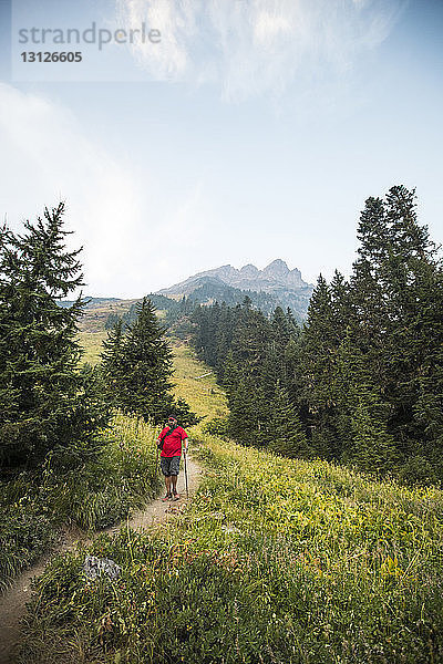 Wanderer in voller Länge auf dem Weg inmitten des Feldes stehend