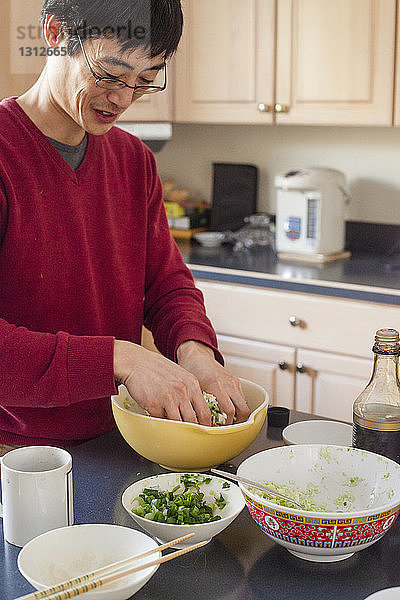 Mann bereitet zu Hause in der Küche das Essen vor