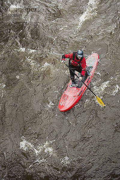 Hochwinkelaufnahme eines Mannes beim Paddelbootfahren im Fluss