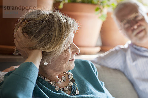 Älteres Ehepaar sitzt zu Hause auf dem Sofa