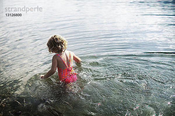 Rückansicht eines Mädchens im Meer an einem sonnigen Tag