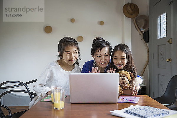 Glückliche Familie macht Videoanrufe mit dem Laptop zu Hause