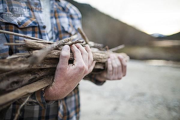 Ein Mann trägt Brennholz im Silver Lake Provincial Park in der Mitte