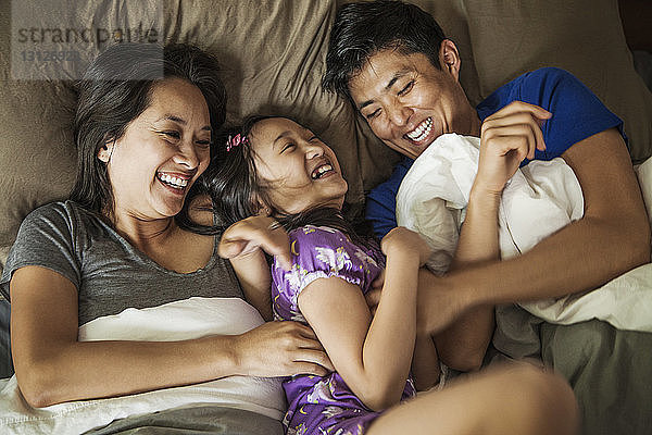 Draufsicht auf glückliche Familie im Bett zu Hause