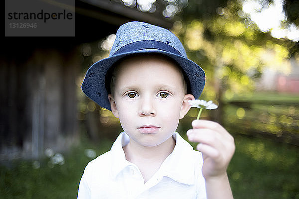 Porträt eines Jungen mit Blume im Park