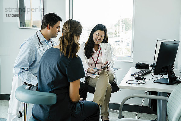 Ärztin zeigt Kollegen im Krankenhaus einen Tablet-PC