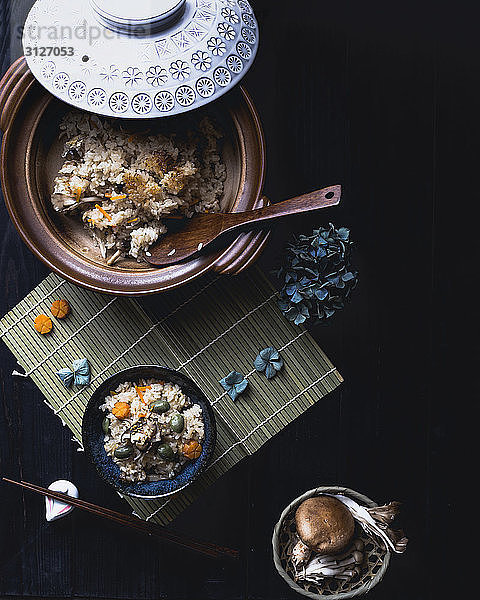 Draufsicht auf Reis und Pilze auf schwarzem Tisch